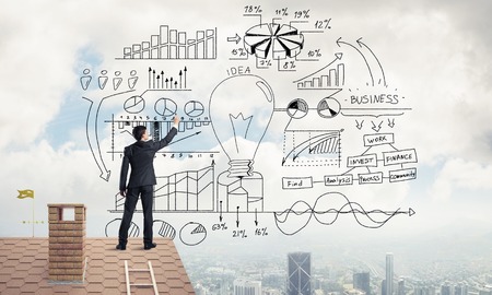 Young man with back sketching business success plan. Mixed mediaの写真素材