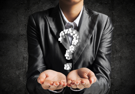 Cropped image of businessman in suit presenting multiple cubes in form of question mark in his hands. 3D rendering.の写真素材