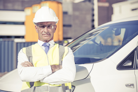 Confident construction engineer in hardhat with arms crossed on chestの写真素材