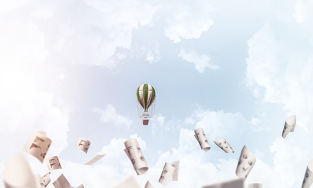 Colorful aerostat flying among paper documents and over the blue cloudy sky. 3D rendering.の写真素材