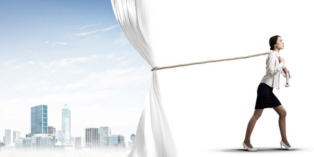 Businesswoman pulling white blank fabric. Place for textの写真素材