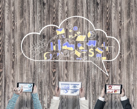 Group of people with devices in hands working together as symbol of networking and communicationの写真素材