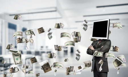 Cropped image of businessman in suit with monitor instead of head keeping arms crossed while standing among flying dollars inside office building.の写真素材