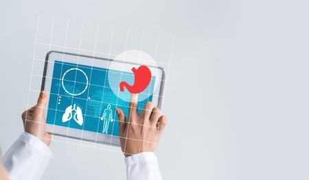 Tablet pc device with medicine interface screen in hands of doctorの写真素材