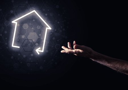Hand of man touching with finger glowing home icon or symbolの写真素材