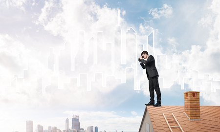 Young businessman viewing cityscape in his binoculars Mixed mediaの写真素材