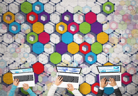 Group of three people with devices in hands working together as symbol of networking and communicationの写真素材