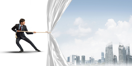 Businessman pulling white blank fabric. Place for textの写真素材