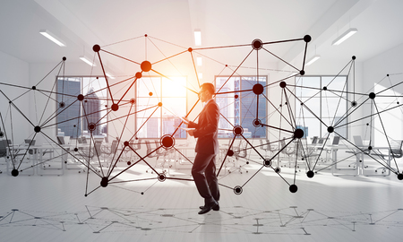 Elegant businessman in modern office interior and social connection concept. Mixed mediaの写真素材