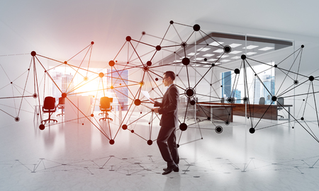 Elegant businessman in modern office interior and social connection concept. Mixed mediaの写真素材
