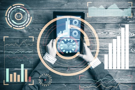 Top view of businesswoman sitting at wooden table with tablet pcの写真素材