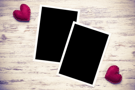 Blank photo frame and love hearts on wooden tableの写真素材