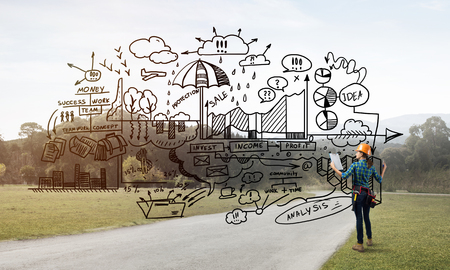 Back view of engineer woman in hardhat outdoor and sketched concept on screenの写真素材