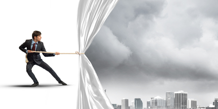 Businessman pulling white blank fabric. Place for textの写真素材
