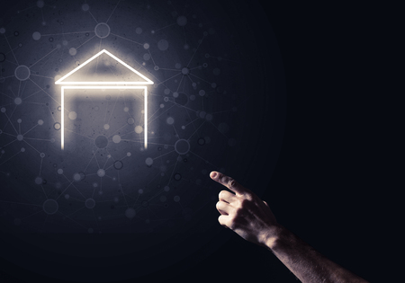 Hand of man touching with finger glowing home icon or symbolの写真素材
