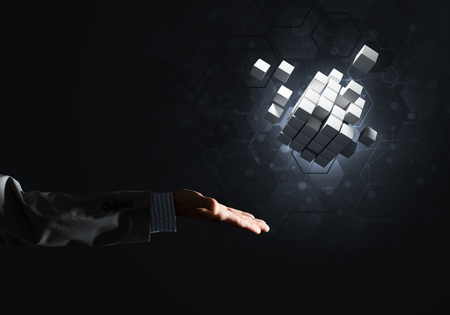 Close of businessman hand holding cube figure as symbol of innovation, mixed mediaの写真素材