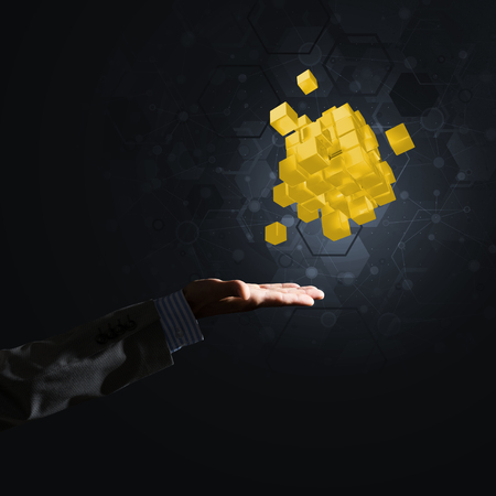Close of businessman hand holding cube figure as symbol of innovation, mixed mediaの写真素材