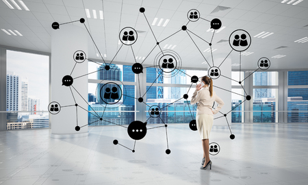 Elegant businesswoman in modern office talking mobile phone and social connection concept. Mixed mediaの写真素材