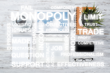 Top view of modern workplace with office stuff and business-related terms above presenting still office lifeの写真素材