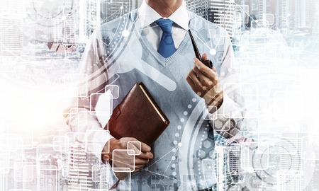 Confident and young businessman in smart-casual wear smoking pipe and modern cityscape with business and media interface. Double exposure Concept of new technologies for modern business.の写真素材