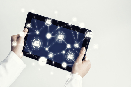 Tablet pc device with connection lines on screen in hands of doctorの写真素材