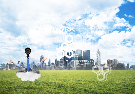 Elegant businessman outdoors floating on cloud and camera instead of headの写真素材