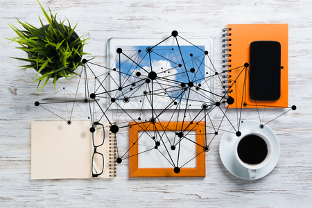 Top view of modern workplace with office stuff and social network connection above as symbol of still office life. Mixed media.の写真素材