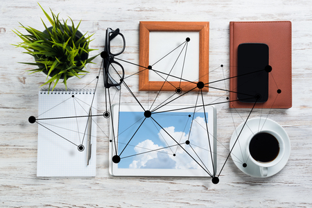 Top view of modern workplace with office stuff and social network connection above as symbol of still office life. Mixed media.の写真素材