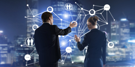 Businessman and businesswoman standing with back and touching connection conceptの写真素材