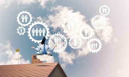 Faceless businessman with camera zoom instead of head sitting in lotus poseの写真素材