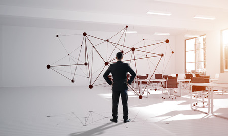 Elegant businessman in modern office interior and social connection concept. Mixed mediaの写真素材