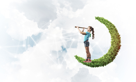 Cute kid girl on green moon and social connection conceptの写真素材