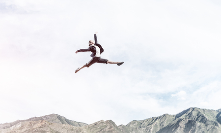 Attractive business woman in suit jumping in the air as symbol of active life position. Skyscape and nature view on background. 3D rendering.の写真素材