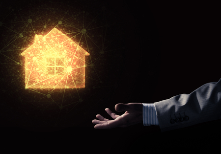 Businessman hand presenting glowing home icon or symbolの写真素材