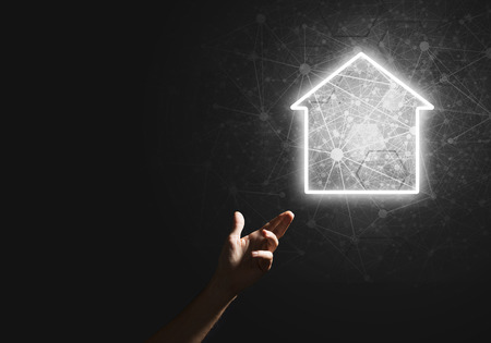 Hand of man touching with finger glowing home icon or symbolの写真素材