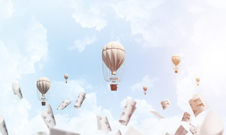 Colorful aerostats flying among paper documents and over the blue cloudy sky. 3D rendering.の写真素材