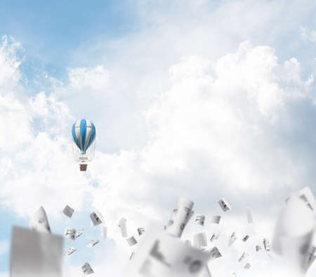 Colorful aerostat flying among paper documents and over the blue cloudy sky. 3D rendering.の写真素材