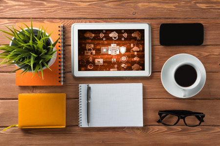 Top view of business workplace with tablet notepad coffee cup and other itemsの写真素材