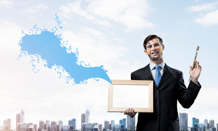 Successful businessman in black suit gesturing and smiling while standing with blue coloured musical splash against cityscape view on background.の写真素材