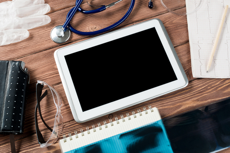 High angle shot of tablet and medical items on wooden tableの写真素材