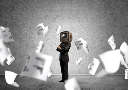 Businessman in a suit standing among flying papersの写真素材