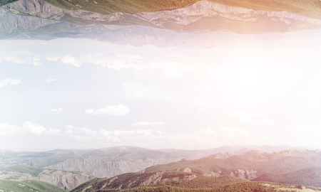 Abstract image of two nature worlds located upside down to each other on sky background. Wallpaper, backdrop with copyspace.の写真素材
