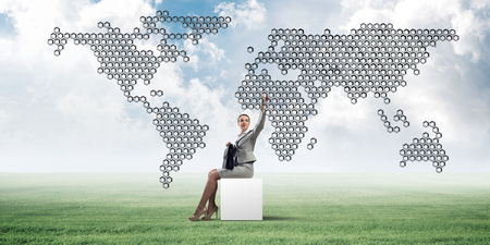 Elegant businesswoman with suitcase in hand sitting on white cubeの写真素材