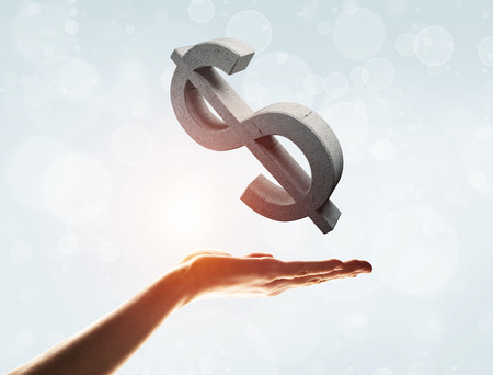 Close of businessman hand showing in palm stone dollar sign. Mixed mediaの写真素材