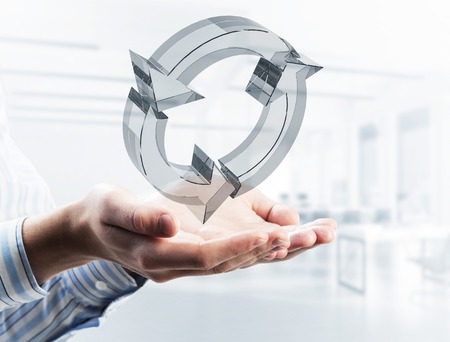 Close of businessman holding in palm reload glass icon. Mixed mediaの写真素材