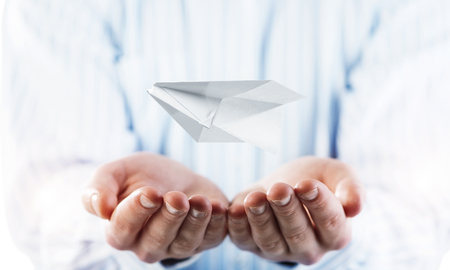 Close of businessman hands holding paper ship as symbol for success. Mixed mediaの写真素材