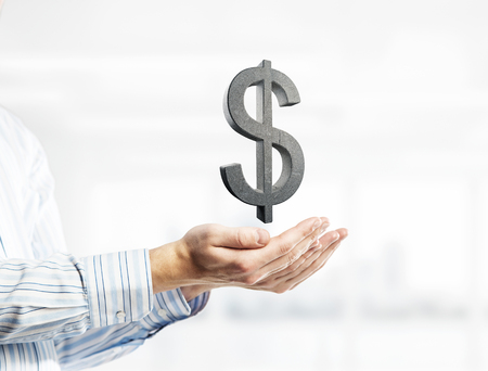 Close of businessman hand showing in palm stone dollar sign. Mixed mediaの写真素材