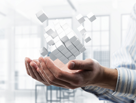 Close of businessman hand holding cube figure as symbol of innovation. 3D renderingの写真素材