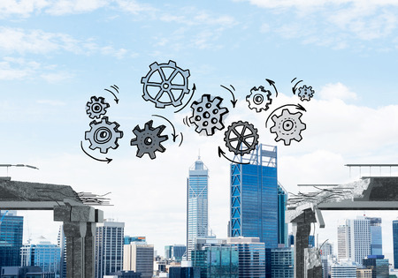 Sketched gear mechanism over gap in concrete bridge as symbol of teamwork and problem solving. Cityscape on background. 3D rendering.の写真素材