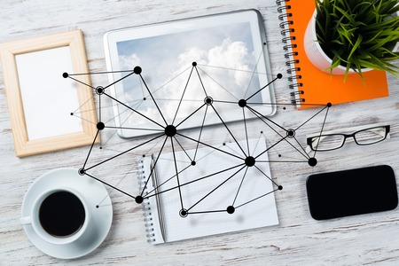 Top view of modern workplace with office stuff and social network connection above as symbol of still office life. Mixed media.の写真素材